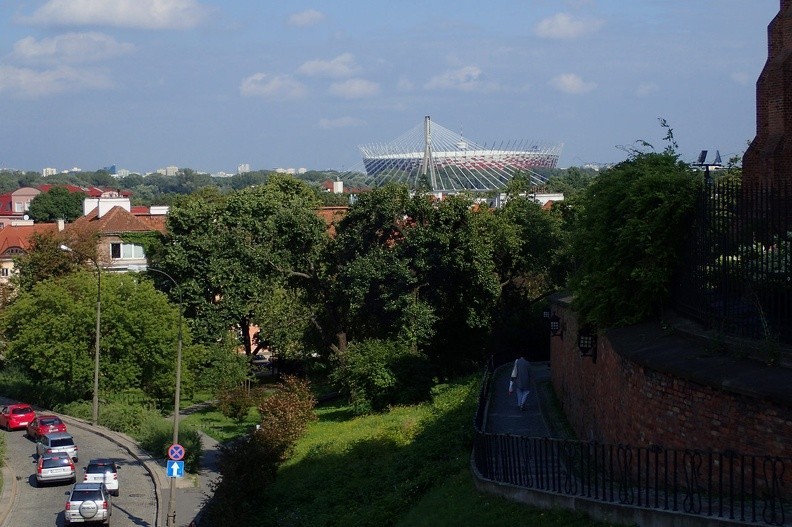 25-P7170073 -- Zielone korony drzew przesłaniają Mariensztat, nad którym wznosi się charakterystyczny pylon Mostu Świętokrzyskiego.
Biało-czerwona "plecionka" w oddali to oczywiście Stadion Narodowy