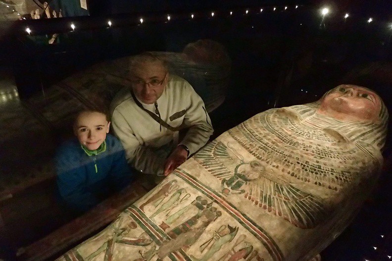 051-P1080272 -- Jak objaśnia dr Krzysztof Babraj, pracownik Muzeum: "Poniżej <i>usechu</i> umieszczono egipski symbol odradzania się, czyli uskrzydlonego skarabeusza trzymającego w przednich odnóżach dysk słoneczny, a w tylnich – znak opieki <i>szen</i>." Scena przedstawiona niżej rozgrywa się wokół stolika ofiarnego na jednej nodze, zwanego gerydonem; widoczne w tym rejestrze bóstwa są "albo synami Horusa, albo strażnikami bram zaświatów"