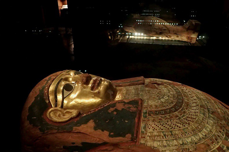 061-P1080299 -- Sarkofag Aset-iri-khet-es, kapłanki bogini Izydy. Natrafił na niego w 1907 roku pierwszy polski egiptolog, Tadeusz Smoleński – uczestnik austro-węgierskiej wyprawy badawczej do al-Gamhud. W drugiej połowie lat 90-tych mumię Aset-iri-khet-es dokładnie przebadano
w Collegium Medicum Uniwersytetu Jagiellońskiego: przeprowadzono m.in. tomografię komputerową, badania fizykochemiczne
i histopatologiczne. Kapłanka miała około 27-30 lat, mierzyła 152 cm wzrostu. Śmierć spowodowana była wykrwawieniem. W opatrunkach odnaleziono części dojrzałych kłosów jęczmienia, którego zbiory odbywały się prawdopodobnie w kwietniu; niewykluczone, że o tej właśnie porze roku (2300 lat temu) miał miejsce pogrzeb. Po zakończeniu badań kapłankę z należytym szacunkiem na powrót owinięto
w bandaże – także w 30 m specjalnie przygotowanego, lnianego bandaża XX-wiecznego