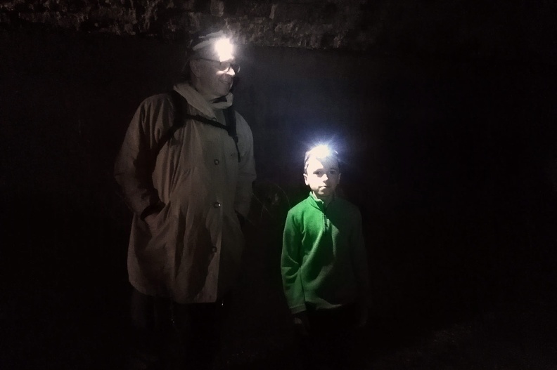 02-IMG 183454 -- Jesteśmy w obszernej komorze zlokalizowanej pod Parkiem Pokoju. Pierwotnie pełniła ona funkcję pałacowej spiżarni,
później Niemcy przekształcili ją w zbiornik przeciwpożarowy. Dzisiaj tego miejsca strzeże (stojący obok Mikołaja) Jerzy G.
[Fot. z telefonu]