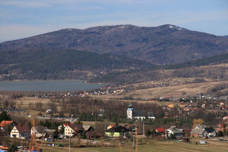 010-IMG 5872 -- Plan dalej, po przeciwnej stronie przełomu Soły, wypiętrza się zachodnia część Beskidu Małego. Widać rzadkie zabudowania na połogich zboczach niskiego, ciemnawego Łysego Gronia. Nad tym ostatnim górują szczyty (od prawej) Rogacza, Czupla i Magurki Wilkowickiej.
Niedaleko od nas, na tle bezlistnych drzew jaśnieje bryła bazyliki świętego Mikołaja – to sanktuarium Matki Bożej Rychwałdzkiej