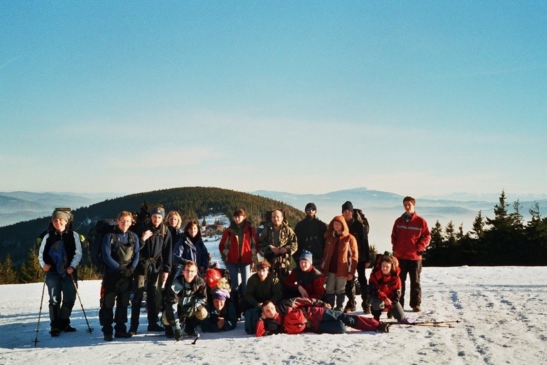 06-0515   0 -- Osoby stojące, od lewej: Juzia, Radeck, Haust, Katarzyna, Anna, dalej (po drugiej stronie widocznego w oddali schroniska) osoba nieznana, Klaus, Mariusz, Hela, nieco zasłaniany przez nią Witold oraz (na końcu) Kamil. Rząd bliżej, też od lewej: Rafał,
Milka (leży, z ogromnym bagażem), Papaj, osoba nieznana i (po przerwie) Ines. Całkiem z przodu, podparty na łokciu: Krzysztof