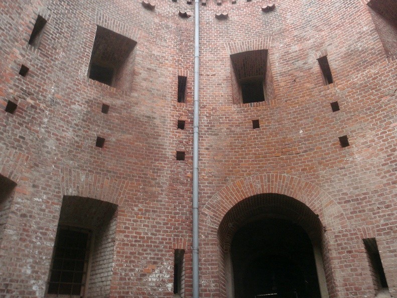 27-PB260444 -- To tzw. <i>Maximilianischer Turm</i>, wieża maksymiliańska – typ budowli wyposażonej w działobitnie, otoczonej fosą, z dziedzińcem pośrodku. Koncepcja ta narodziła się po klęsce Austriaków pod Ebelsbergiem: w maju 1809 roku rozgromiły ich wojska Napoleona I Bonapartego, który następnie zajął stolicę nad Dunajem. Pojawiła się potrzeba lepszego zabezpieczenia kraju. W latach 1831-1834 w taki właśnie, "wieżowy" sposób ufortyfikowano Linz, opierając się na planach arcyksięcia Maximiliana Josepha von Österreich-Este (więcej: <a href="http://www.burgen-austria.com/archive.php?id=881" target="_blank">LINK 1</a>,
<a href="http://www.novaczek.at/linz.html" target="_blank">LINK 2</a>). Podobne twierdze strzegą Werony, Ulm czy Lwowa. Fort "Benedykt" został zaprojektowany przez Feliksa Księżarskiego (autora Collegium Novum UJ); tutaj średnica zewnętrznych murów wynosi 38 metrów, a średnica (widocznego na zdjęciu) dziedzińca – 8 metrów
[Fot. Mikołaj]