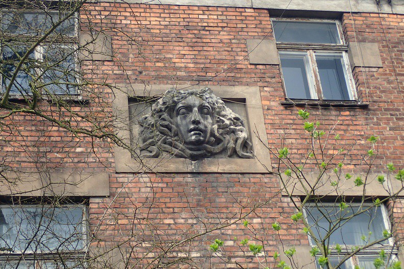 24-P4130067 -- Urodzony w 1923 roku parę kroków stąd, przy ulicy Kraszewskiego, Gustaw Holoubek tak zapamiętał Salwator z czasów dzieciństwa: "W tym zakątku właśnie, u stóp wzgórza, wśród  dziesiątków  sadów,  straszliwie  bogatych  w  czereśnie,  jabłka,  gruszki  i  śliwki, gnieździły  się  wille,  omszałe,  starożytne,  strzeżone  przez  psy, a  mieszkańców  tych domostw, przynajmniej za mojego dzieciństwa, nikt nigdy nie widział. Nic więc dziwnego, że w tym miejscu zatopionym w wiecznym cieniu miały swoje siedlisko wszystkie strachy świata. Wampiry [...]. To stamtąd wyruszały, aby [...] polować jesienią albo słotną zimą, [...] kiedy na nas, zapatrzonych w migotanie świec w bocznych nawach kościołów,
z ram obrazów wychodzili brodaci święci, by grozić piekłem za zatajone grzechy, albo kiedy zmrok zapadał tak prędko, że już nikogo
nie było na ulicy i musiało się biec do dalekiego jeszcze domu tunelem otwartych, czarnych bram kamienic. Toteż  ciągnęło  nas  w  to  salwatorskie  osiedle, aby  poprzez  szpary  w  sztachetach, rozsunąwszy kryjące widok zarośla, ujrzeć wreszcie, jak w biały dzień wyglądają upiory. Ale ledwo drgnęła zasłona jakiegoś zapomnianego okna albo z trudem zaczęły się uchylać nie otwierane nigdy drzwi – braliśmy nogi za pas i uciekaliśmy jak ścigane zające" (<i>Wspomnienia z niepamięci</i>, Warszawa 2000, s. 20). Zbliżenie na Meduzę: <a href="http://www.dziennikgorski.type.pl/zdjecia/pojedyncze/P4130067.jpg" target="_blank">LINK</a>