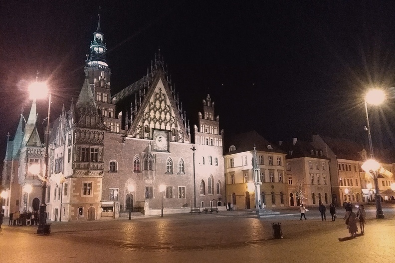 44-IMG 20180424 223522 -- Rynek we Wrocławiu. Na zdjęciu: wschodnia elewacja Starego Ratusza z XIII/XIV wieku, przed którym stoi kopia XV-wiecznego pręgierza. Widoczne dalej, klasycystyczne kamienice należą, tak jak Ratusz, do śródrynkowego bloku budynków – dawniej były tu sukiennice. Zejdziemy (w celach niekonsumpcyjnych) do działającego na tyłach Ratusza minibrowaru "Spiż". Obejrzymy podświetlaną fontannę <i>Zdrój</i> (według projektu profesora Alojzego Gryta z wrocławskiej Akademii Sztuk Pięknych). Ulica Wita Stwosza zaprowadzi nas z Rynku
do przystanku Galeria Dominikańska. Pomkniemy tramwajem przez Wyspę Piasek i Wyspę Młyńską na plac Bema, w pobliżu którego zacumowaliśmy srebrny krążownik. Po pożegnaniu się z Adamem czeka nas 250-kilometrowy samochoding przez noc
[Fot. z telefonu]