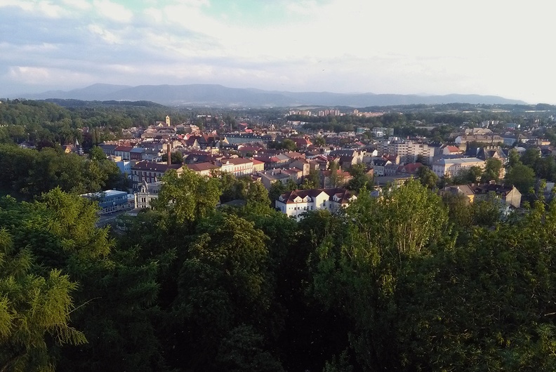 16-IMG 194243 -- Spojrzenie na południe: tuż za ścianą drzew – Czeski Cieszyn, z tyłu – Beskid Śląsko-Morawski. Jego pierwszy wybitniejszy szczyt po lewej
to Ostrý, plan bliżej mamy grzbiet od Malého Javorového do Javorového. Na prawo od tego ostatniego nieznacznie wybrzusza się  Ropice. Dalsza część wału gór jest długa i słabo zróżnicowana; zarówno Travný, jak i Lysá hora z Malchorem są tak szarawe, że prawie niewidoczne. Wał ów kończą Čupel, Prašivá i Malá Prašivá (nad rzeką Morávkou). Fotografia w większym rozmiarze: <a href="http://www.dziennikgorski.type.pl/zdjecia/pojedyncze/IMG_194243.jpg" target="_blank">LINK</a>
[Fot. z telefonu]