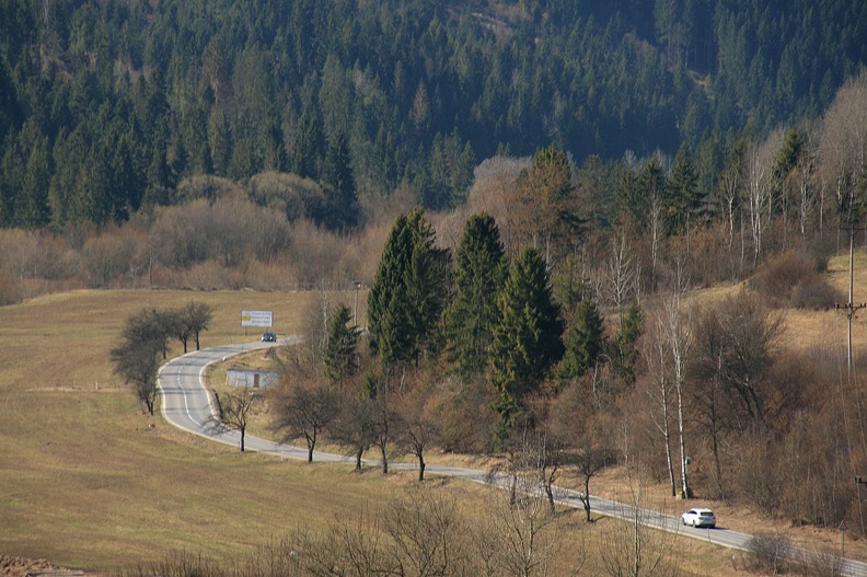 024-IMG 6368 -- Widoczna na zdjęciu szosa szerokim zakrętem okrąża od południa zbocza skorušinského Prasatína; biegnie z Podbiela do Zuberca.
Na przestrzeni wielu lat przejeżdżaliśmy nią dziesiątki razy – zawsze podążaliśmy w różne inne góry i zawsze intrygowały nas wzniesienia oglądane po drodze przez szybę. Właśnie dlatego tu dziś dotarliśmy: aby zrealizować marzenie o powałęsaniu się po tych orawskich grzbiecikach