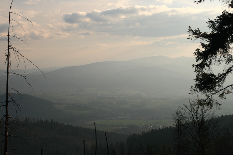 128-IMG 7119 -- Ech... Ciemna górka po lewej to Zielona (Zelená, 604 m n.p.m.) nad miasteczkiem Jabłonków (Jablunkov). Po zachodniej stronie doliny potoku Osetnica (Ošetnice) zaczyna się Beskid Śląsko-Morawski. Jako dwa rozmyte, łagodne kształty prezentują się Mała Skałka i Skałka (Malá Skalka, 798 m n.p.m., i Skalka, 932 m n.p.m.). Tuż za tą ostatnią niesłychanie subtelnie zaznaczają się Kościółki (Kostelky, 962 m n.p.m.). Olbrzymem z tyłu jest Wielki Połom; znajduje się on już na granicy Czech i Słowacji. Za nim usadowił się Burkowy Wierch
(Burkův vrch, 1032 m n.p.m.)
